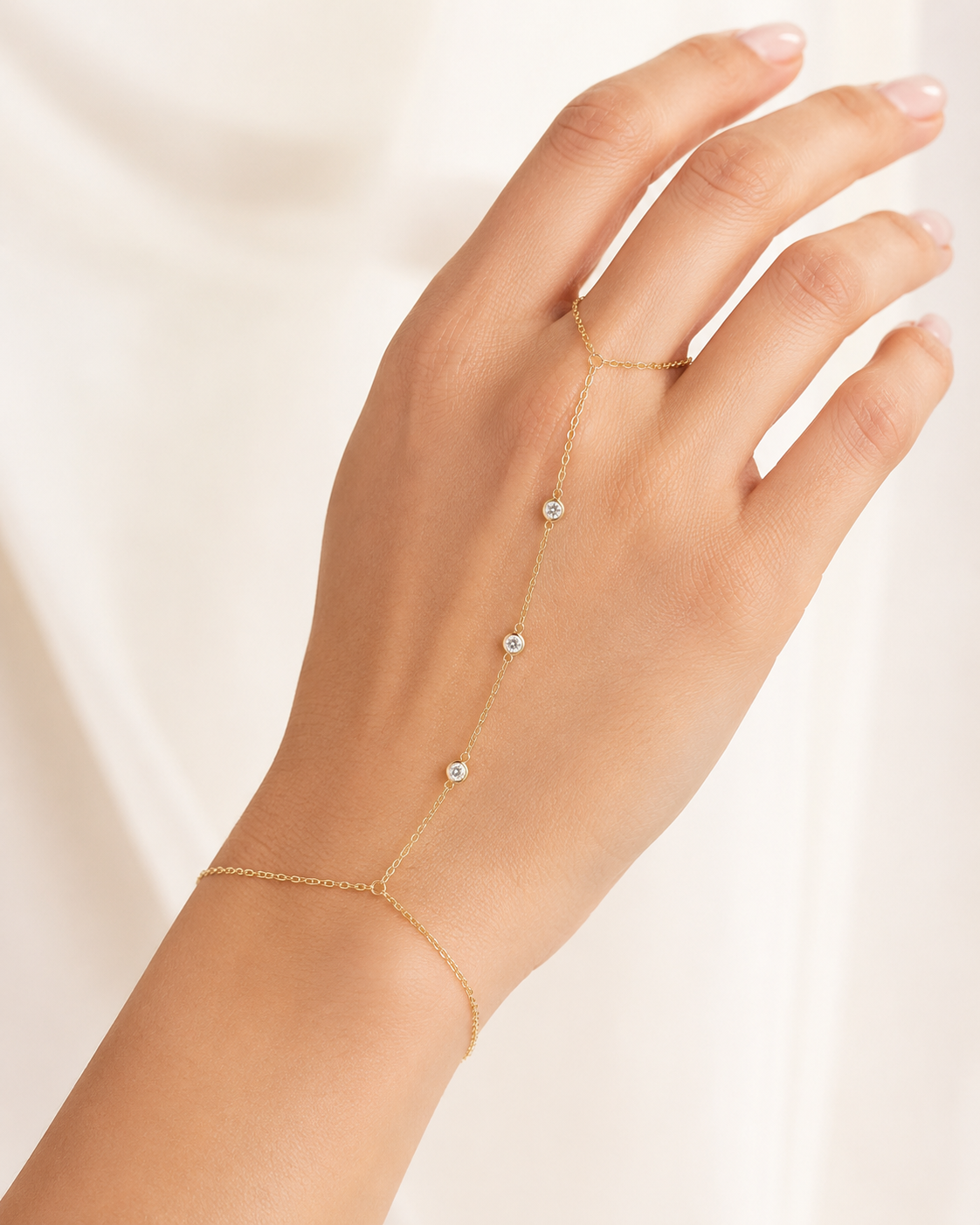 Gold bezel hand chain worn across the hand