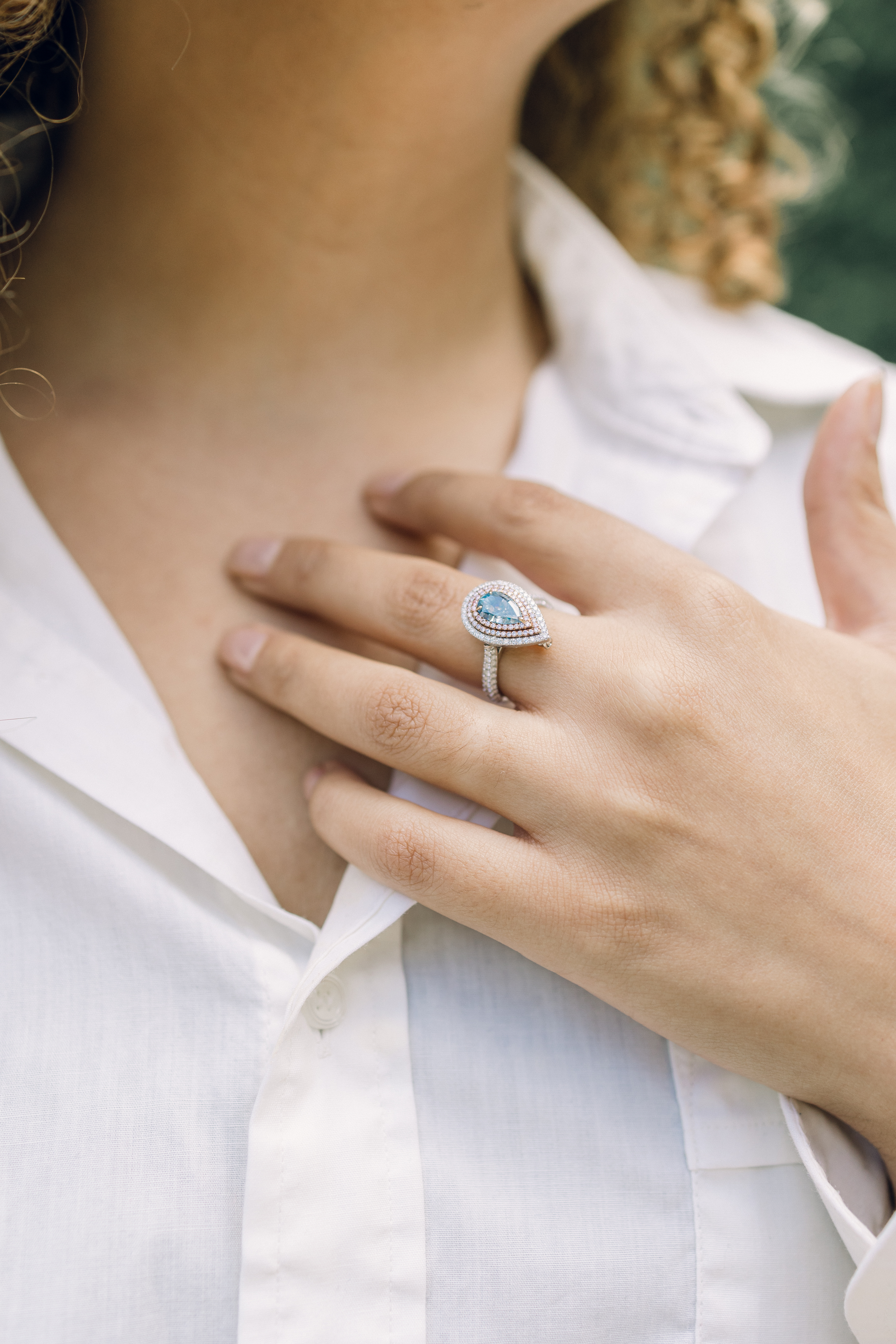 Pear halo ring worn with a crisp white shirt