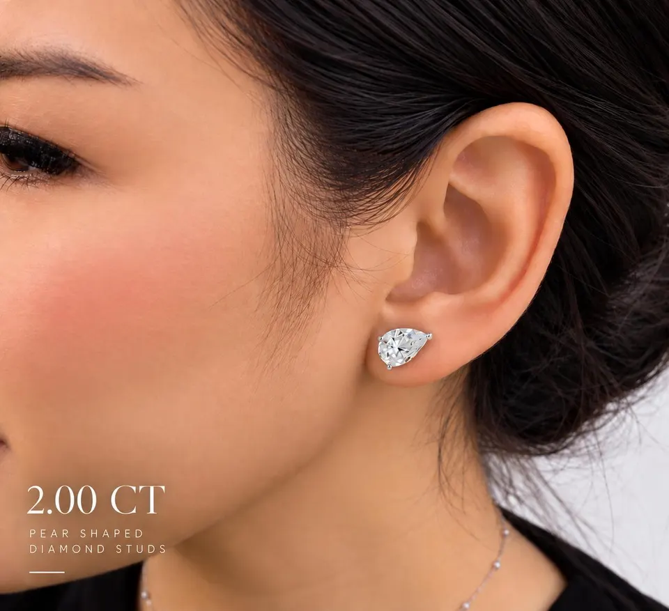 Pear diamond stud worn — 2.00 ct size reference supplied by the atelier