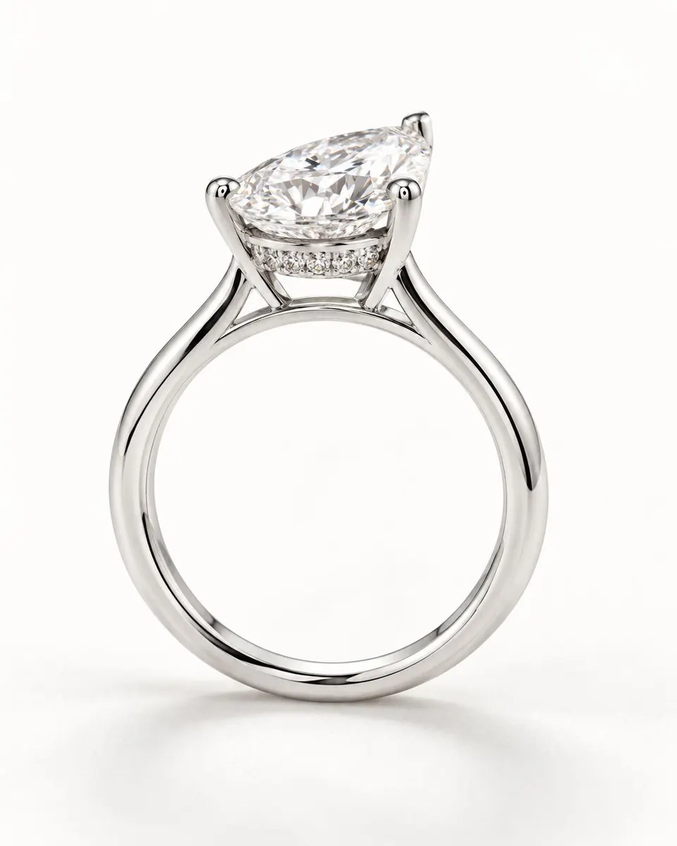 Side view showing the hidden diamond halo beneath the pear centre