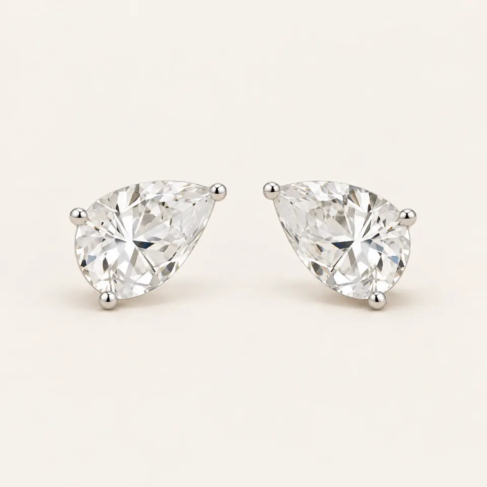 Pair of pear-shaped diamond solitaire stud earrings with minimal three-prong settings