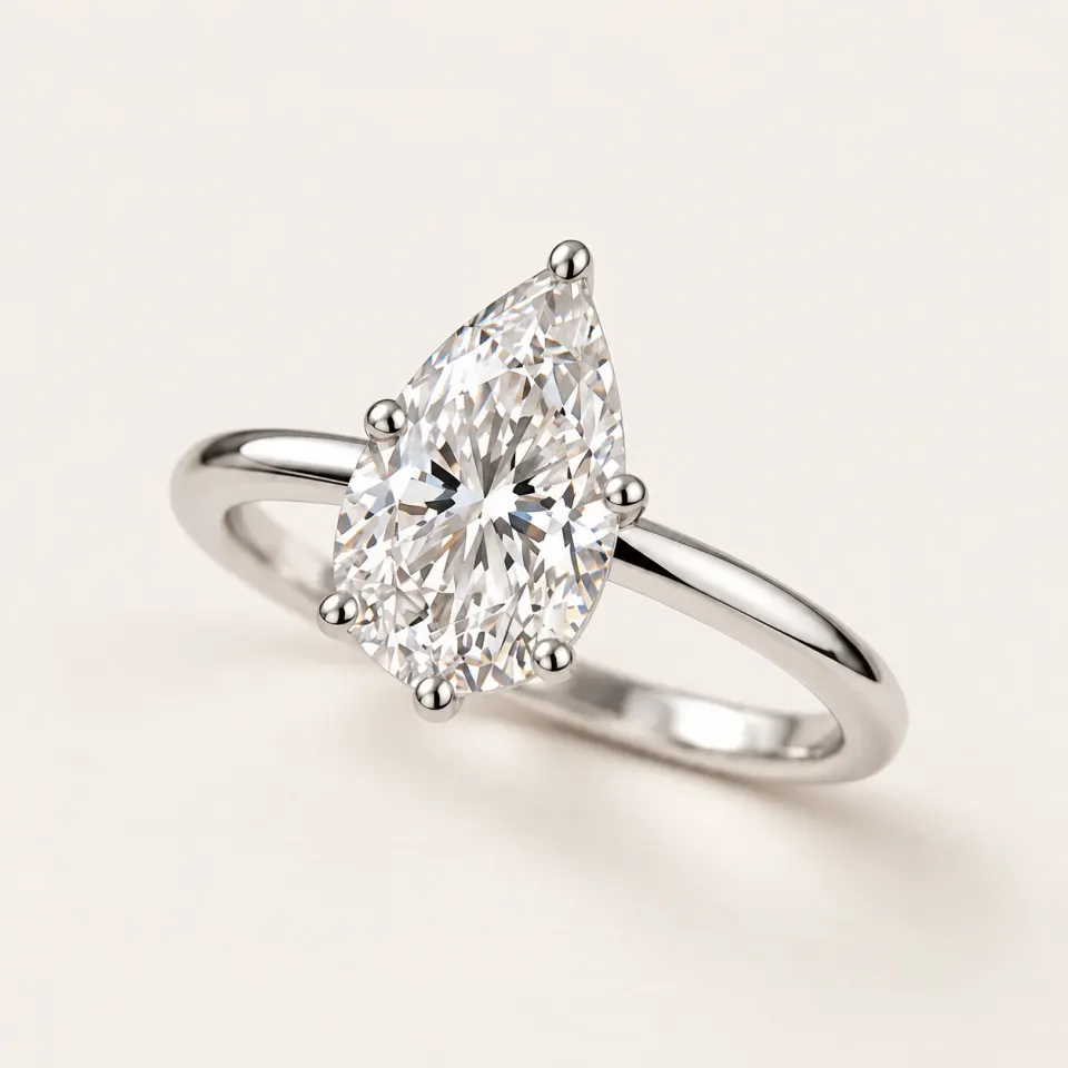 Pear diamond solitaire in polished white gold with eagle-claw prongs and a hidden halo